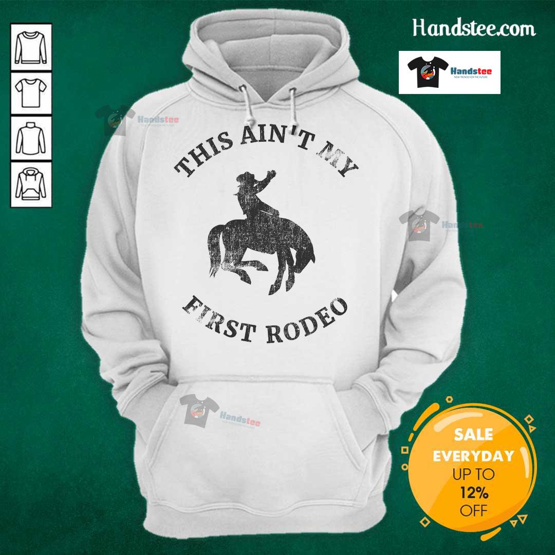 Alt Text: Cowboy wearing an Ain't My First Rodeo hoodie while riding a bronc horse, showcasing rodeo spirit and style.
