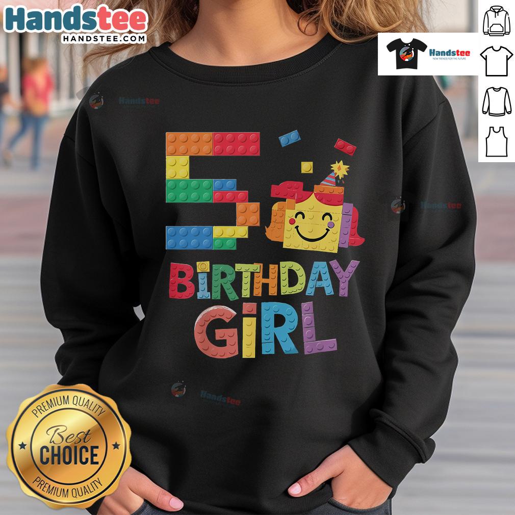 5th birthday girl in a colorful sweatshirt, building with brick blocks, celebrating her special day with creativity.