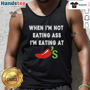 Official When I'm Not Eating Ass I'm Eating at Chili's Tank Top design featuring bold text and vibrant colors.