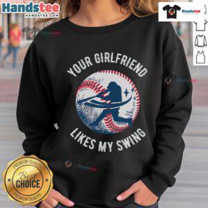 Funny Your Girlfriend Likes My Swing baseball sweatshirt worn by a smiling person at a baseball field, showcasing humor.