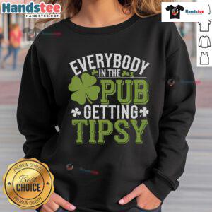 Group of friends in a pub wearing St. Patrick's Day sweatshirts, enjoying drinks and celebrating together.