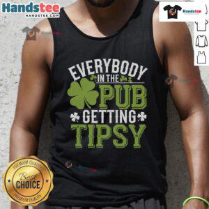 People enjoying drinks in a pub wearing St. Patrick's Day tank tops, celebrating and getting tipsy together.