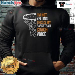 Basketball coach wearing a hoodie that says 'This is my basketball coach voice,' smiling and engaging with players.