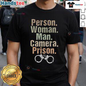 Funny person wearing a prison-themed T-shirt poses with a man and a camera, showcasing unique style and humor.