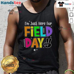 Teacher wearing 'Good, I'm Just Here for Field Day' tank top, enjoying a sunny outdoor school event.