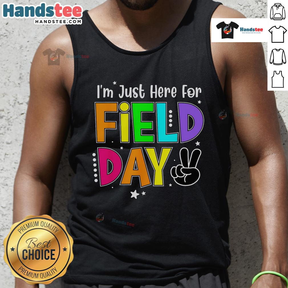 Teacher wearing 'Good, I'm Just Here for Field Day' tank top, enjoying a sunny outdoor school event.