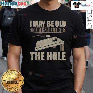 Funny cornhole t-shirt saying 'I May Be Old But I Still Find The Hole' perfect for cornhole enthusiasts.