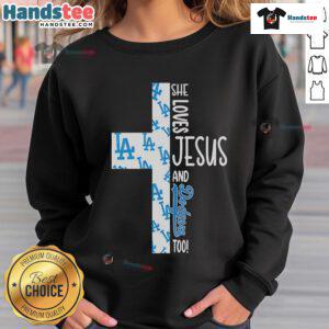 Cozy sweatshirt featuring 'She Loves Jesus and Los Angeles Dodgers Too' design, perfect for fans of faith and baseball.