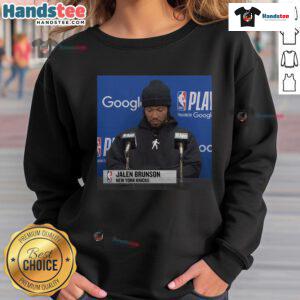 Jalen Brunson at an official press conference wearing a stylish sweatshirt, showcasing his signature style.
