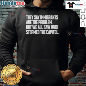 Hot hoodie with text 'They say immigrants are the problem, but we all saw who stormed the Capitol' highlighting immigration issues.