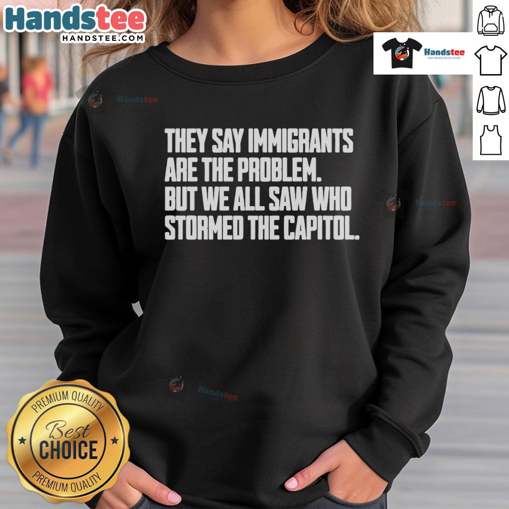 Hot sweatshirt with text 'They Say Immigrants Are The Problem, But We All Saw Who Stormed The Capitol' addressing immigration issues.
