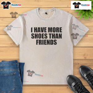 Funny 'Good I Have More Shoes Than Friends' washed t-shirt displayed on a hanger in a stylish closet.