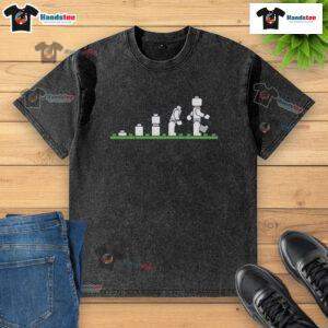 Alt Text: Funny Lego human evolution graphic on a washed t-shirt, showcasing playful Lego characters in evolution stages.