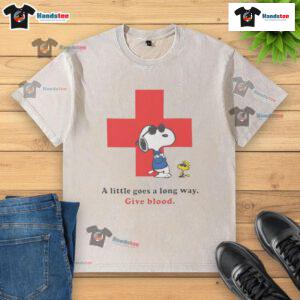 Alt Text: American Red Cross peanuts Snoopy t-shirt promoting blood donation with 'A Little Goes A Long Way' slogan.