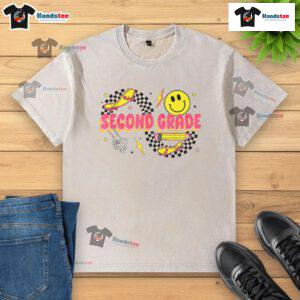 Alt Text: Retro smiley face design on a second-grade back-to-school washed t-shirt featuring a skateboard and pencil.