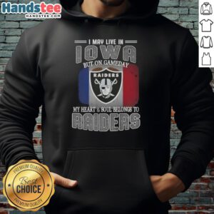 Person wearing an 'I May Live In Iowa But On Gameday My Heart And Soul Belongs To Raiders' hoodie, showcasing team pride.