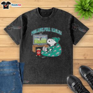 Awesome Philadelphia Eagles Snoopy cozy game day Peanuts style washed t-shirt featuring playful graphics and vibrant colors.