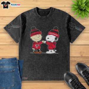 Charlie Brown and Snoopy fist bump on a washed T-shirt featuring Atlanta Falcons logo, celebrating good vibes and football.