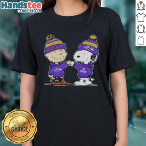 Peanuts Charlie Brown fist bump with Snoopy on a Baltimore Ravens football ladies tee, perfect for fans.