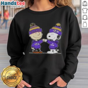 Charlie Brown and Snoopy fist bump in a Baltimore Ravens football sweatshirt, celebrating friendship and team spirit.