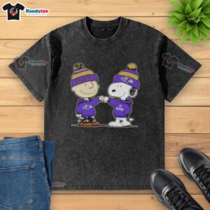 Good Peanuts Charlie Brown and Snoopy fist bump on a Baltimore Ravens football washed t-shirt design.