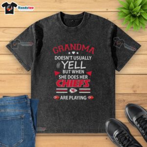 Nice grandma wearing a faded Kansas City Chiefs t-shirt, excitedly cheering during a football game.