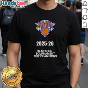 Alt Text: 2025-26 New York Knicks In-Season Tournament Cup Champions T-Shirt featuring team logo and vibrant design.