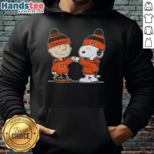 Alt Text: Charlie Brown fist bumping Snoopy in Cincinnati Bengals football hoodie, celebrating team spirit and friendship.