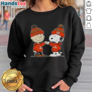 Charlie Brown and Snoopy fist bump in Cleveland Browns sweatshirt, showcasing a fun Nice Peanuts design for football fans.