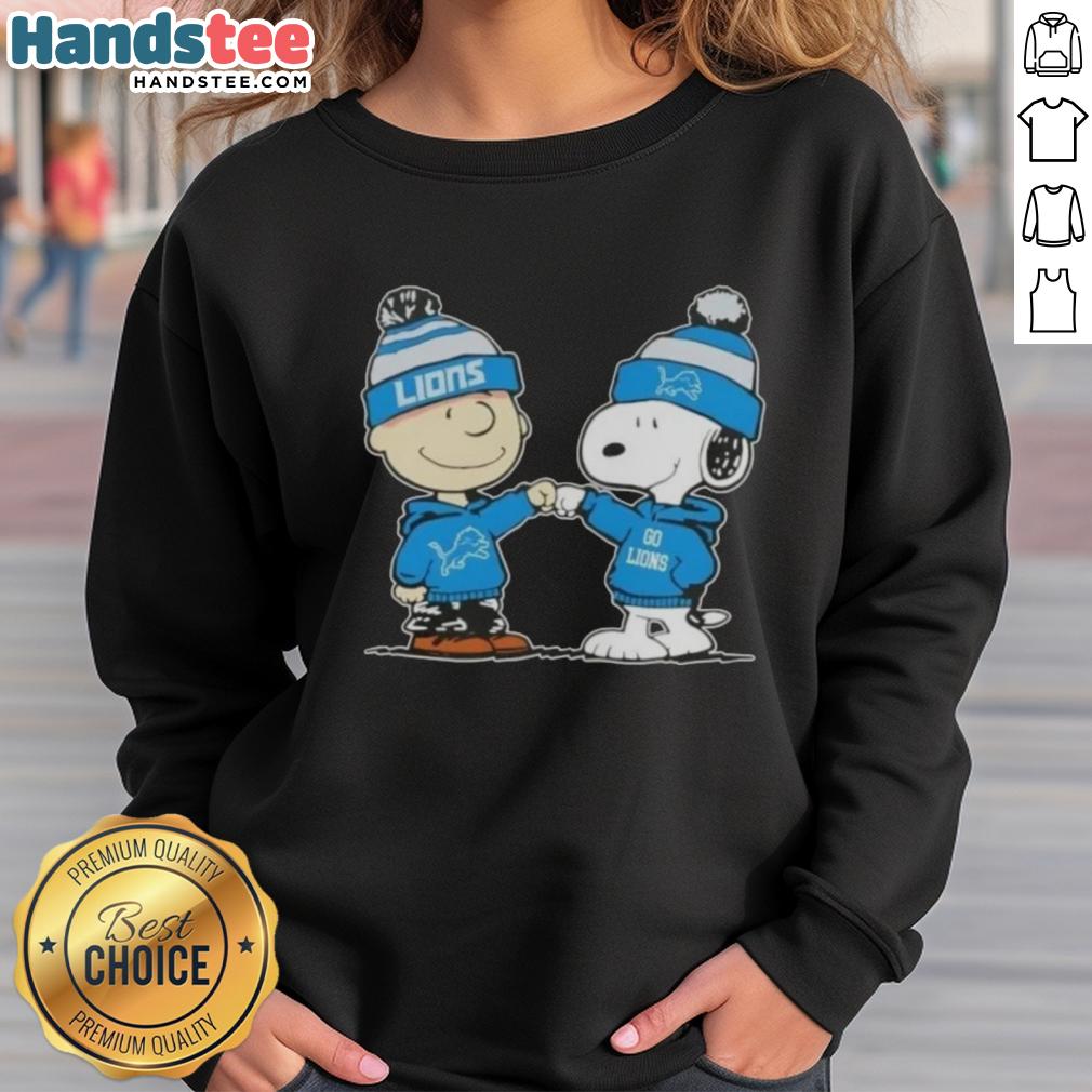 Charlie Brown and Snoopy fist bump on a Detroit Lions football sweatshirt, perfect for Peanuts fans and sports lovers.