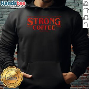 Nice strong coffee in a mug next to a Stranger Things hoodie on a cozy couch, perfect for fans and coffee lovers.