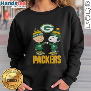 Official Charlie Brown fist bump with Snoopy on a Green Bay Packers sweatshirt, perfect for fans and cozy wear.