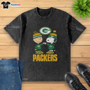 Official Charlie Brown fist bump with Snoopy on a Green Bay Packers washed t-shirt, perfect for fans and collectors.