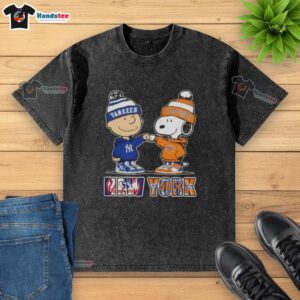 Alt Text: Official Charlie Brown fist bump with Snoopy on a washed t-shirt featuring New York City Yankees and Knicks sports logos.