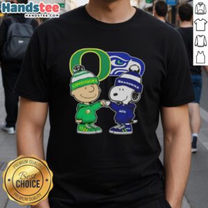 Alt Text: Official Charlie Brown fist bump Snoopy graphic on Oregon Ducks X Seattle Seahawks T-shirt for fans.