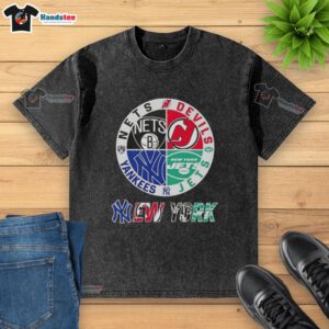 Good New York City sports shirt featuring logos of Nets, Devils, Jets, and Yankees in a stylish, washed design.