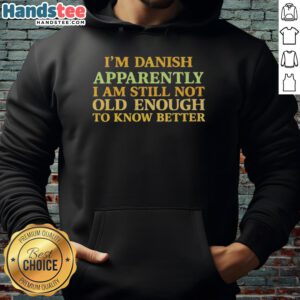 Young person wearing a 'Nice, I'm Danish, Apparently I Am Still Not Old Enough To Know Better' hoodie, smiling outdoors.