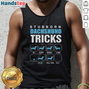 Nice stubborn Dachshund wearing a tank top showcasing fun tricks in a sunny backyard setting.