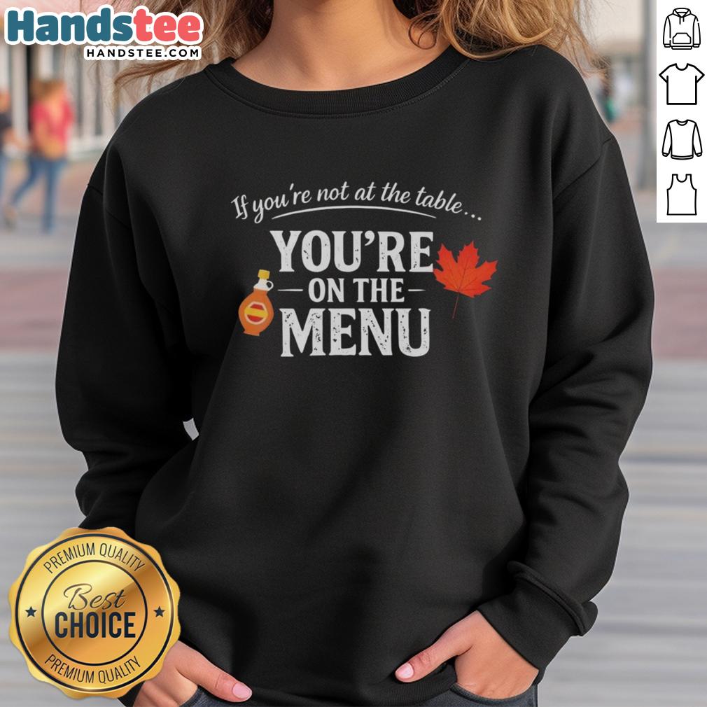 Original 'If You're Not at the Table, You're on the Menu' sweatshirt featuring bold text design on a cozy fabric.