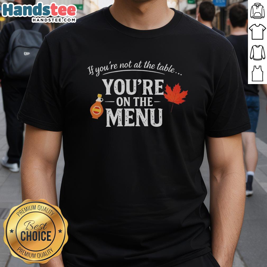 Alt Text: Original If You're Not At The Table, You're On The Menu T-Shirt design featuring bold typography on a casual tee.