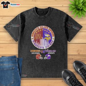 Alt Text: Stylish washed t-shirt featuring a mashup of Minnesota Golden Gophers and Vikings helmet logos for game day.