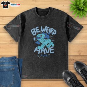 Nice Be Weird Have Fun washed t-shirt displayed on a wooden background, perfect for casual, fun-loving fashion enthusiasts.