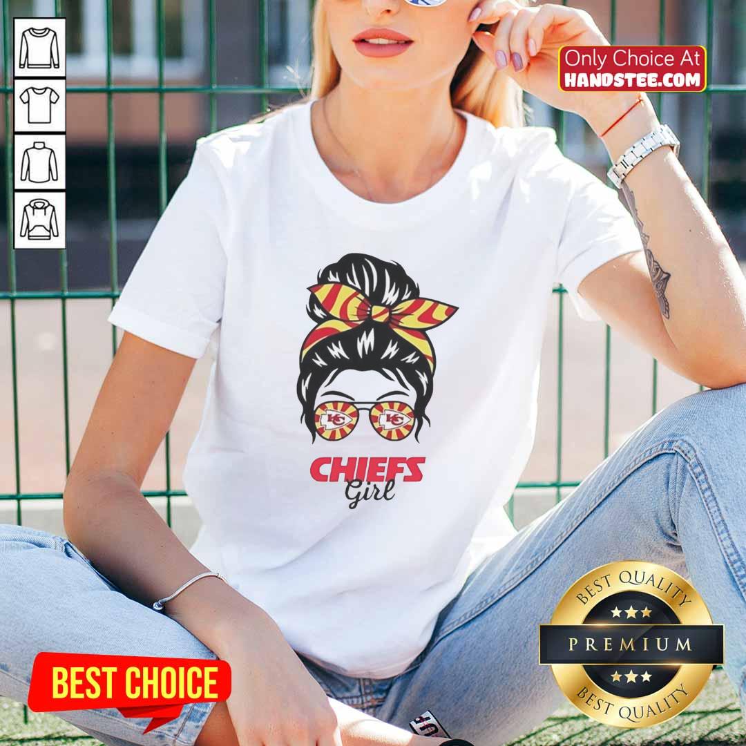 Cheerful Kansas City Chiefs girl in a messy bun and glasses wearing a stylish ladies tee, showcasing team spirit.