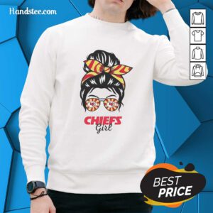 Cheerful Kansas City Chiefs girl in a messy bun, wearing glasses and a stylish sweatshirt, showing team spirit.