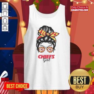 Cheerful Kansas City Chiefs girl with a messy bun, wearing glasses and a tank top, showcasing team spirit at a game.