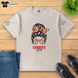 Girl in messy bun and glasses wearing a washed Kansas City Chiefs t-shirt, showcasing team spirit and casual style.