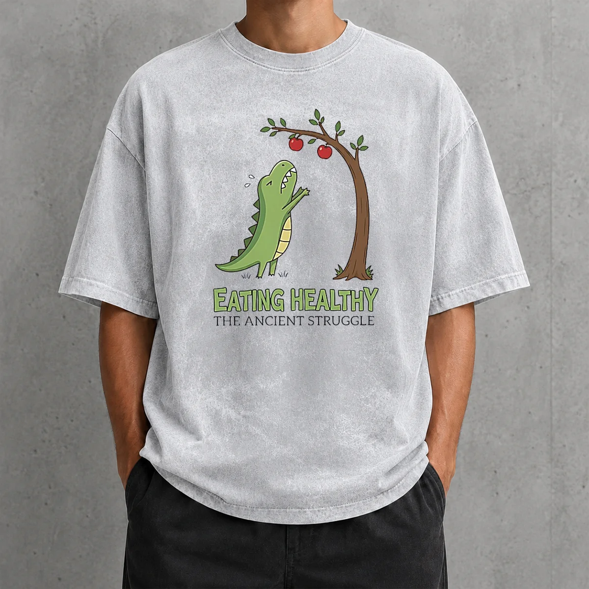 Funny T Rex Eating Healthy The Ancient Struggle design on a soft washed t shirt in light gray