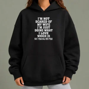 Official I'M Not Scared Of My Wife I'M Just Doing What I Love Not Making Her Mad Hoodie in black, long-sleeve pullover with front pocket and printed text